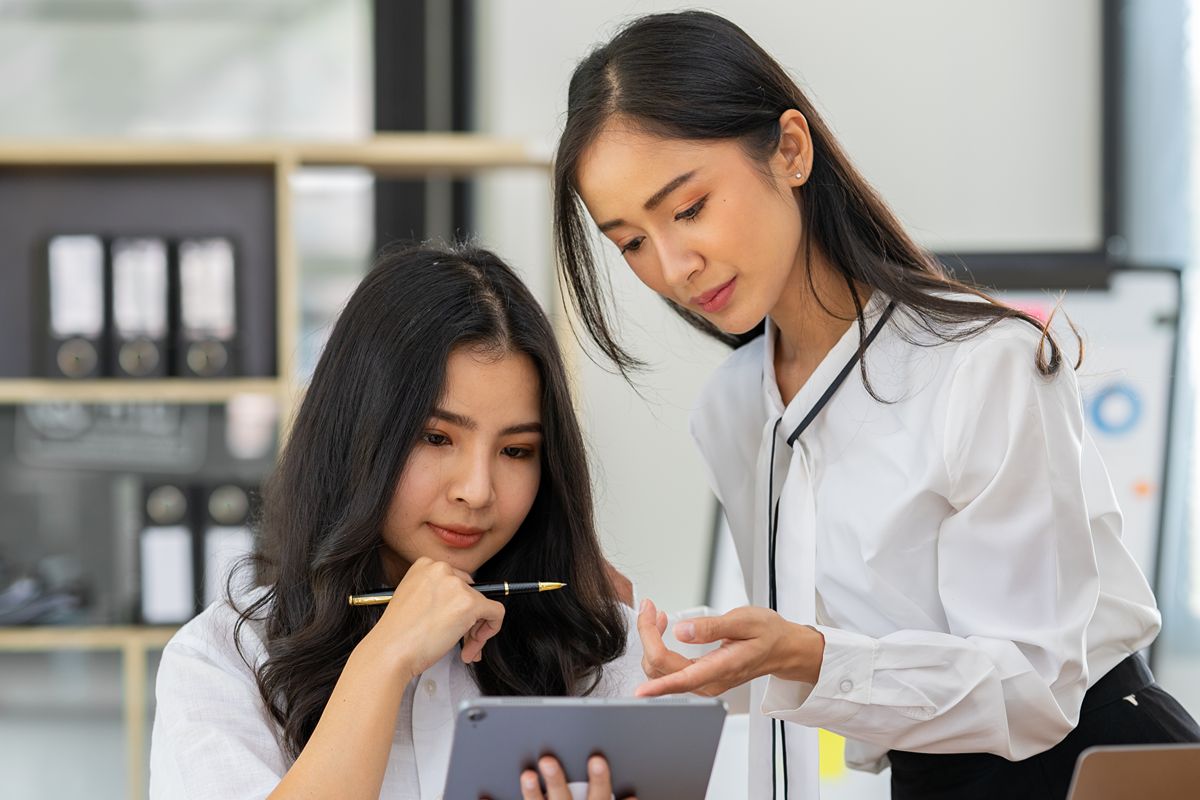 Professionals reviewing executive talent acquisition details on a tablet