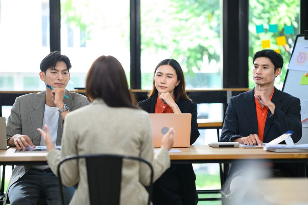 Executive search consultant discussing confidential leadership hiring with professionals in a private meeting