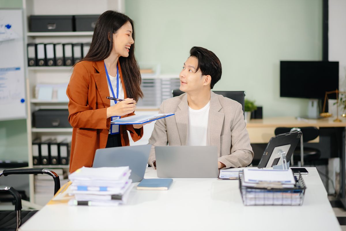 Recruitment professional discussing executive search strategies and talent mapping with a colleague in an office