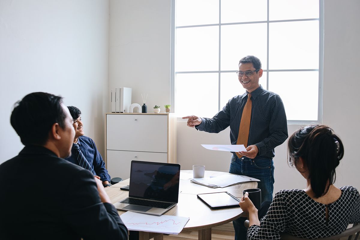 Recruitment specialist presenting executive search strategies to business professionals during an office meeting