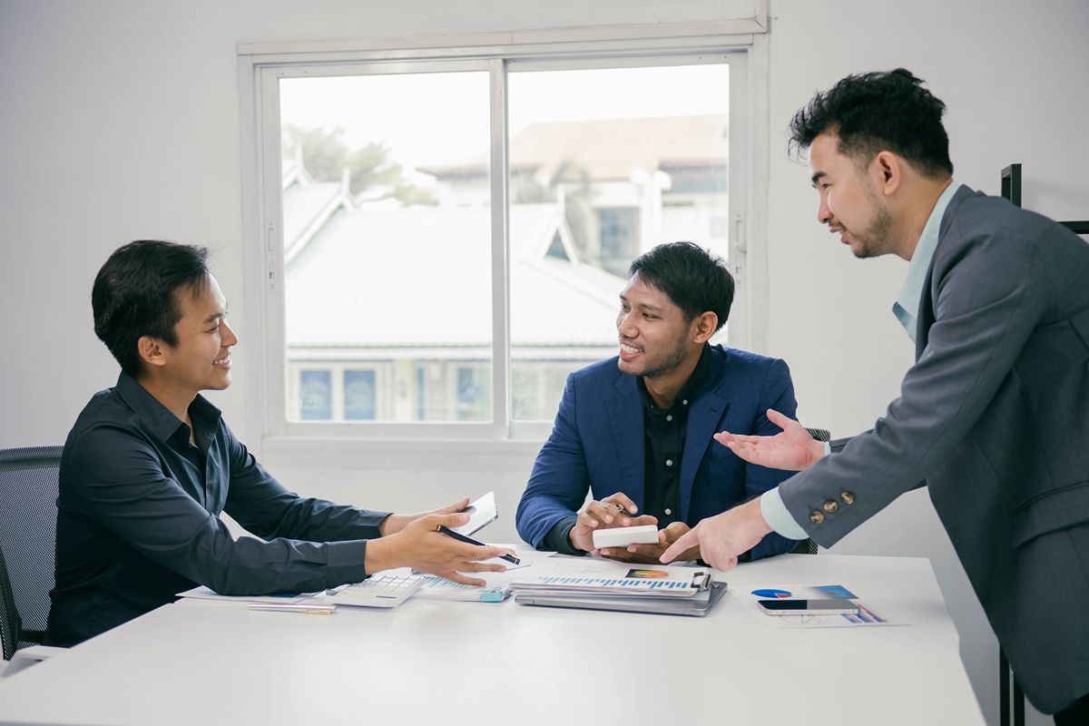 Executive search consultants discussing recruitment opportunities and passive talent sourcing during a business meeting